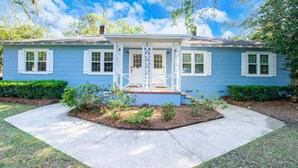 A single-story house with a front porch, a small garden area, and a clear sky. - Cottage @ Midtown - Central Location! (Duplex) (Tallahassee)
