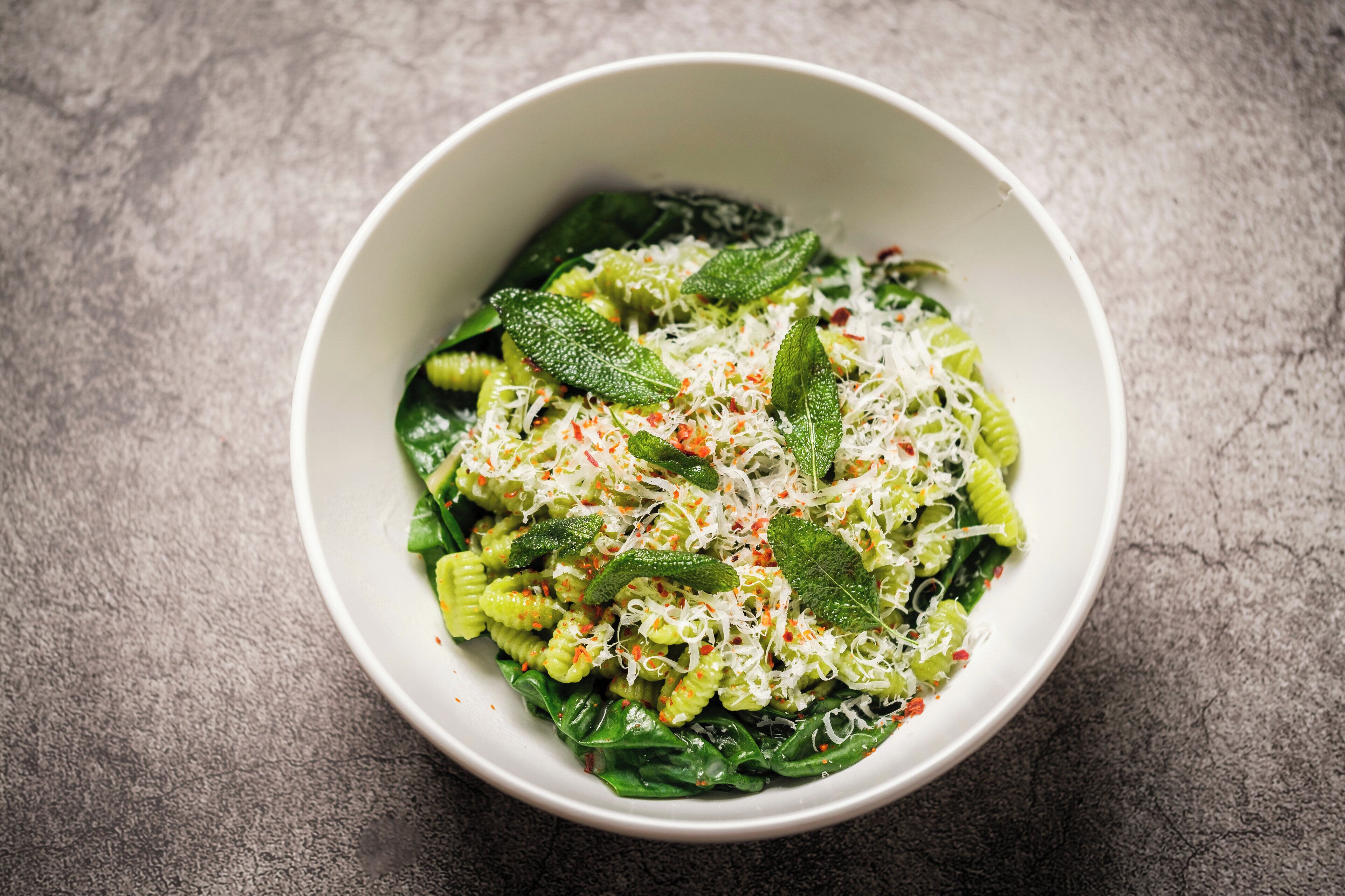 Ensalada de pasta con verduras verdes y queso.
