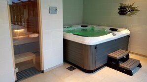 A bathroom with a hot tub, wooden steps, and a small shelf. - L'Albizia Maison d'Hôtes (Libin)