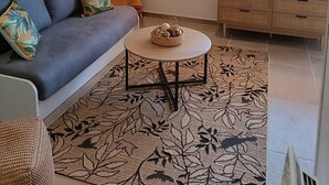 Ein modernes Wohnzimmer mit Sofa, Couchtisch und Dekorationselementen.