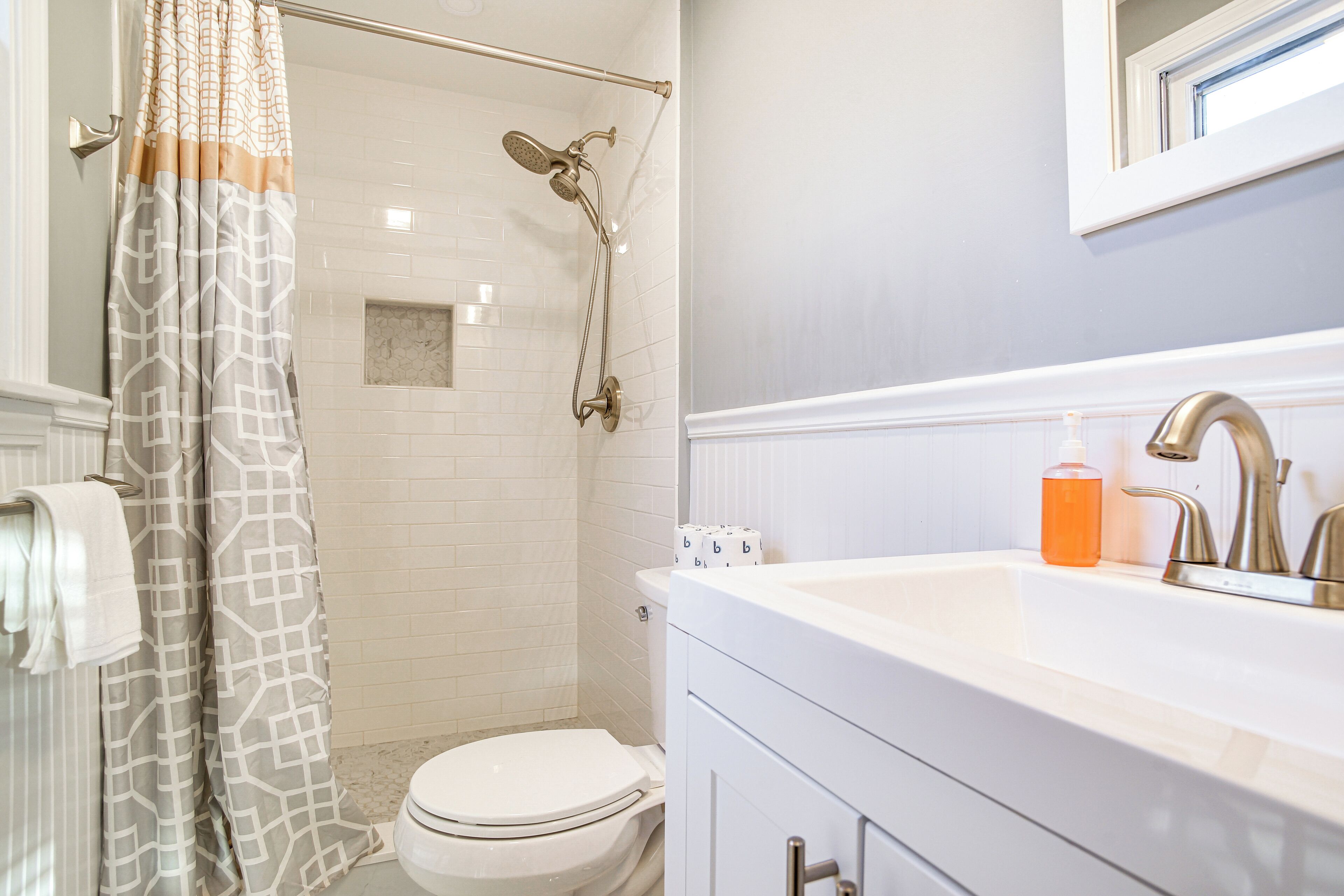 A bathroom with a shower, toilet, and sink.