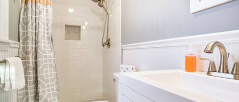 A bathroom with a shower, toilet, and sink.