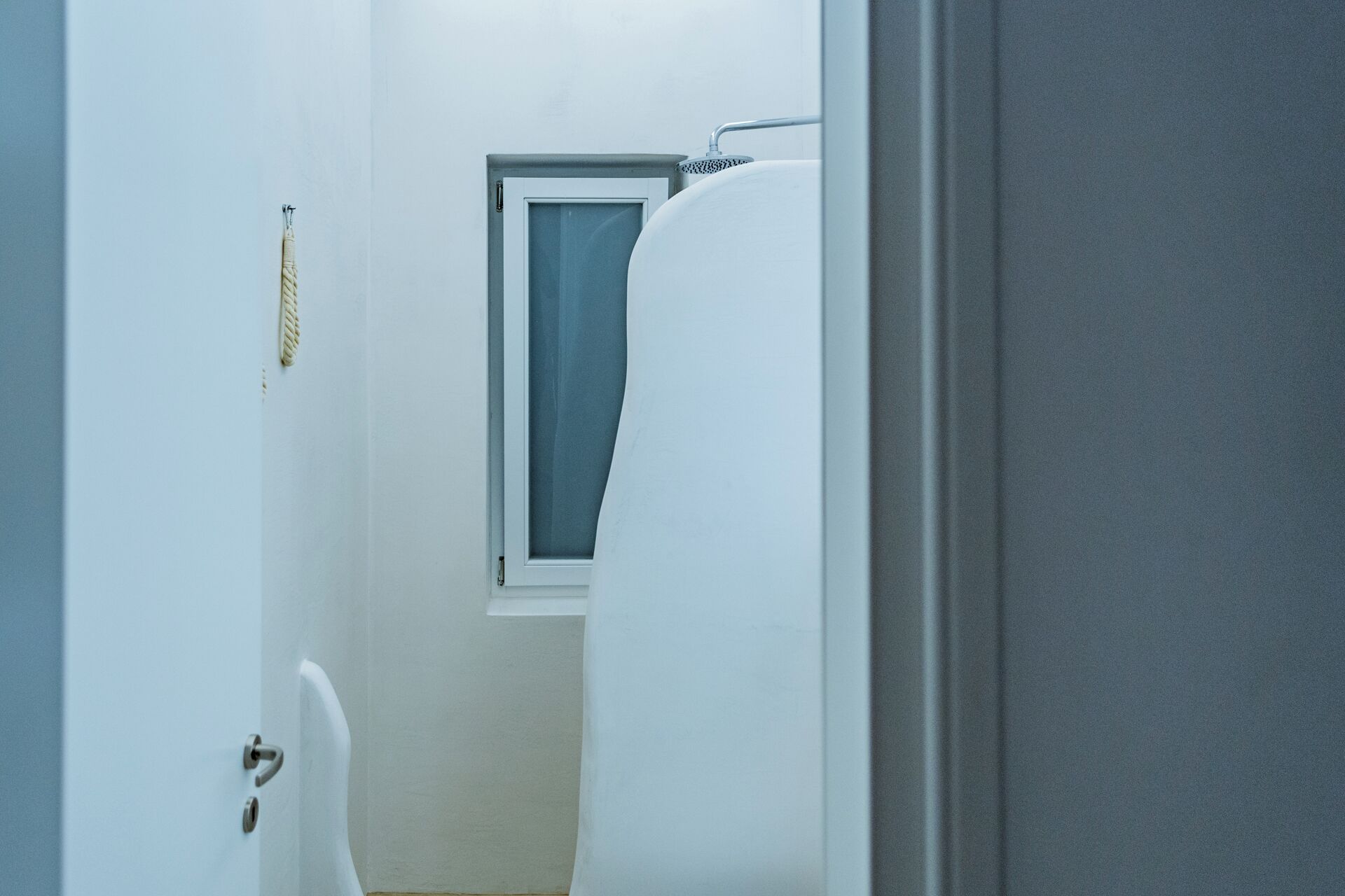 A narrow hallway with a door leading to a bathroom.