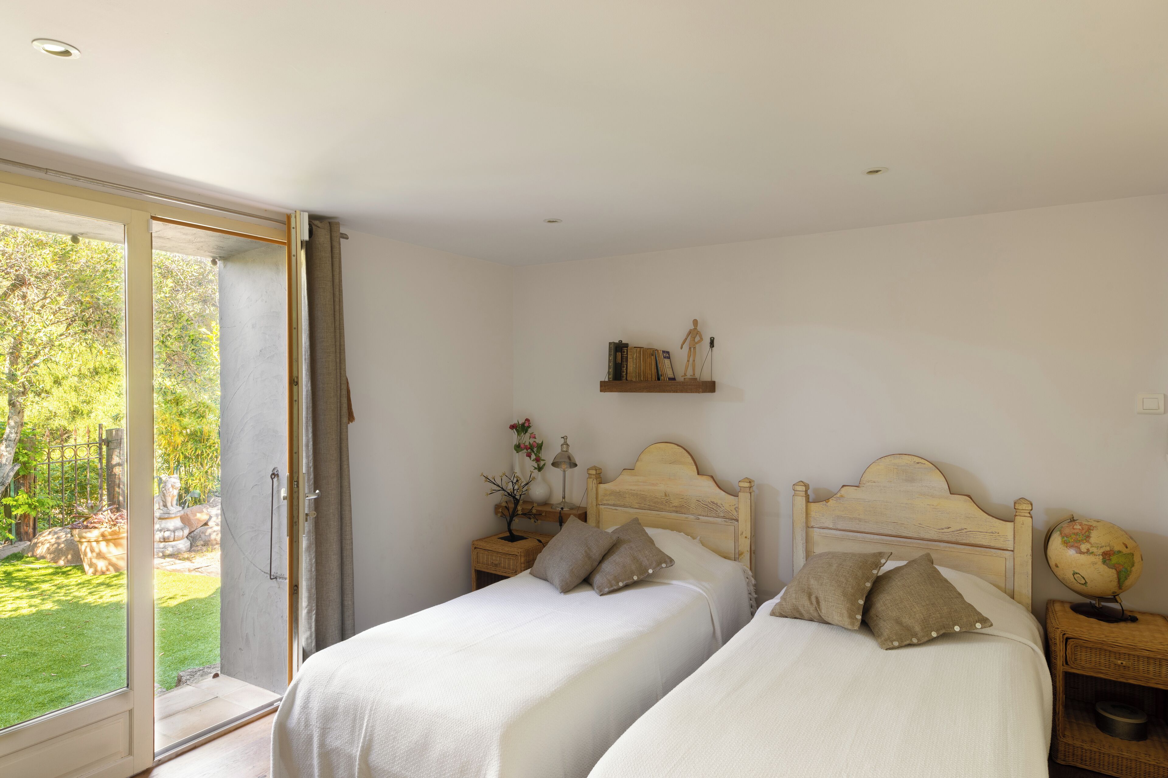 Un dormitorio con dos camas, un ventanal y vistas al exterior.