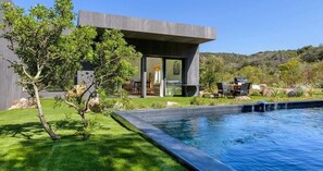 A modern house with a swimming pool, a patio with outdoor furniture, and a view of the surrounding landscape. - Les Villas de Palombaggia (Porto-Vecchio)