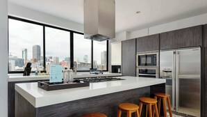 Una cucina moderna con un'isola grande, elettrodomestici in acciaio inossidabile e vista sulla città.