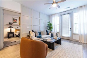 Ein modernes Wohnzimmer mit einer Couch, einem Couchtisch und einem Deckenventilator.