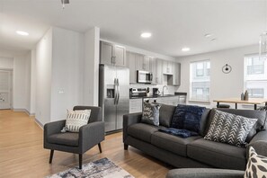 A modern apartment with a living room, kitchen, and dining area.