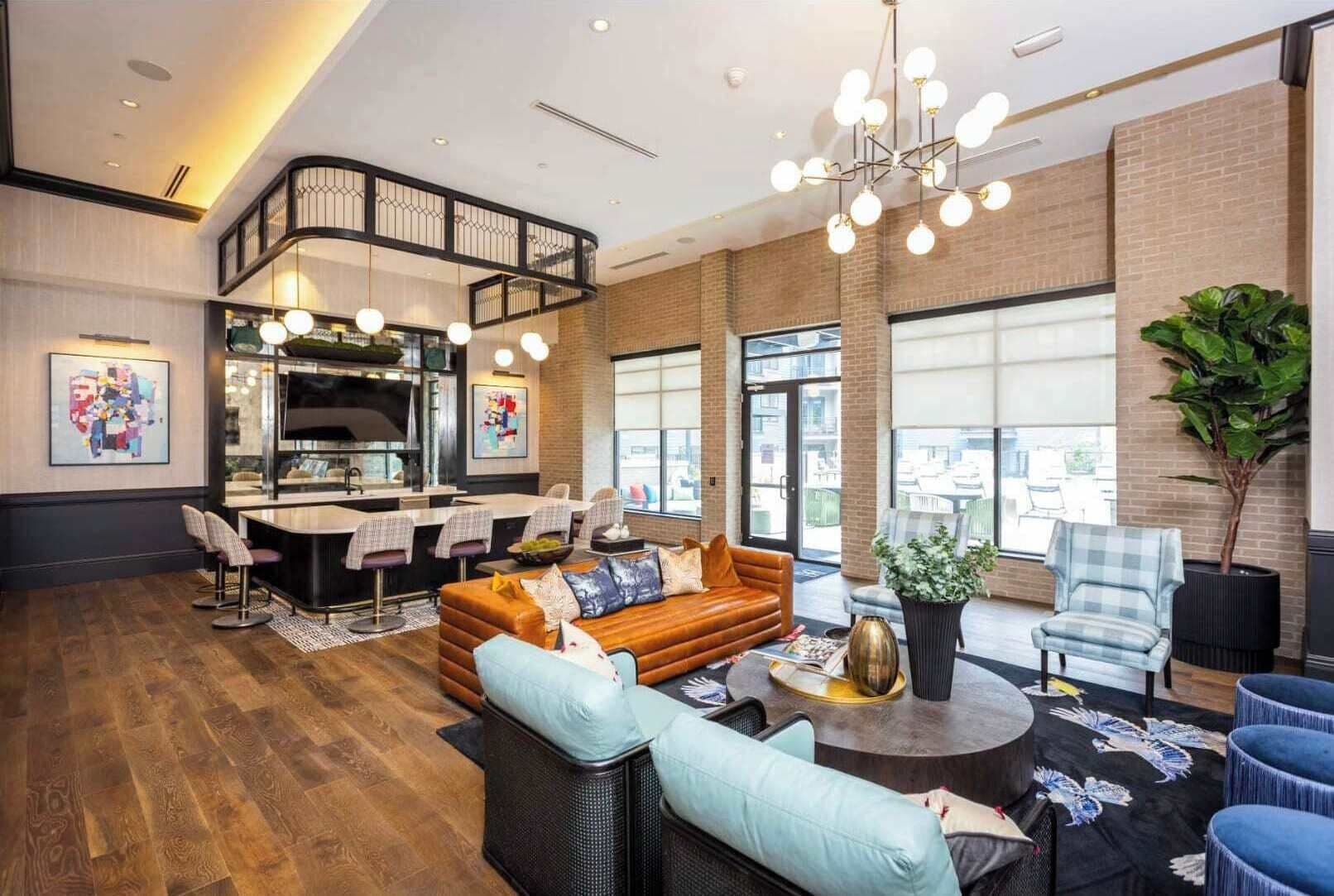 A modern hotel lobby with a kitchen area, seating arrangements, and large windows.