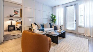 A modern living room with a sofa, coffee table, and a ceiling fan. - Stay Where It’s Happening! Chic Cincy Condo (Cincinnati)