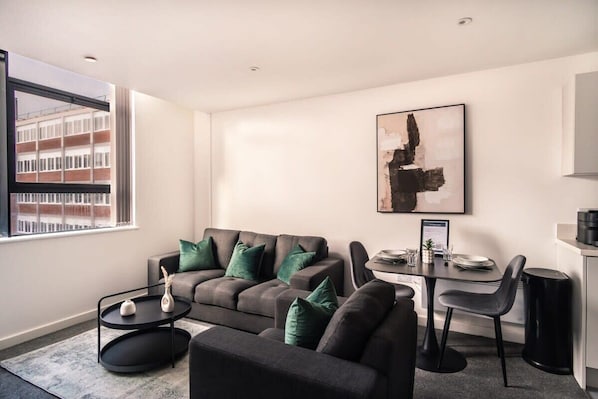A modern living room with a sofa set, a dining table, and a coffee table.