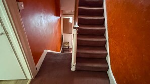 A staircase with a carpeted floor and wooden handrails, leading to an upper floor. - Walton Apartment (London)