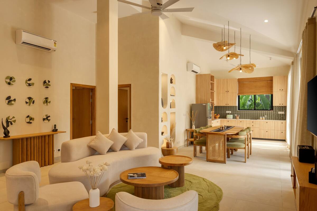 A modern living room with a sofa, coffee table, and dining area.