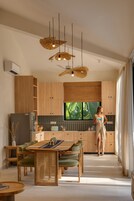 Una cucina moderna con mobili in legno, un'ampia televisione a schermo piatto e un'area pranzo con tavolo e sedie.