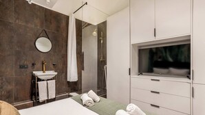 A modern bathroom with a shower, sink, and a bed with towels. - 4 Chambres, 4 Salles de Bains Proche Gare de Lyon (Paris)