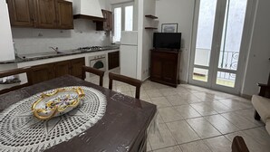 Een keuken met houten kastjes, een fornuis en een eettafel met een decoratief middelpunt.