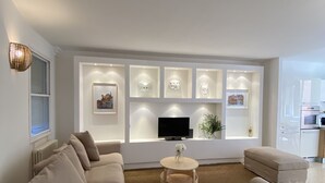 A modern living room with a beige sofa, a round coffee table, and a flat-screen TV. - Magdalena's House (Venezia)