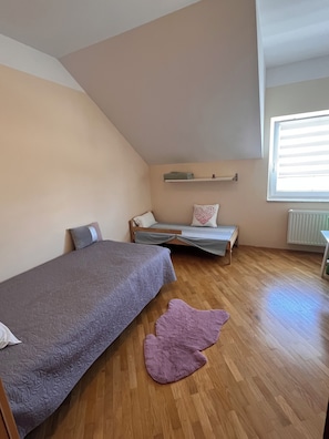A bedroom with a bunk bed, a single bed, a window with blinds, and a radiator. - Peaceful house 4 room house in Maribor - bike friendly (Upravna enota Maribor)