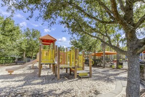Explore the playground area with a slide, climbing elements, and a shaded play space.