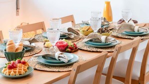 A dining table set with plates, glasses, and a bottle of orange juice.