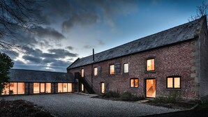 A brick building with multiple windows and a staircase leading to the entrance. - The Barn at Plas Ashpool -  a beautiful converted barn sleeping 12 guests (Llandyrnog)