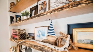 A rustic wooden shelf with various decorative items including a framed picture, a small sailboat model, and a sign that reads "LAKE MICHIGAN".