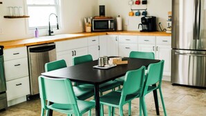 Una cocina con una mesa, sillas y un refrigerador.