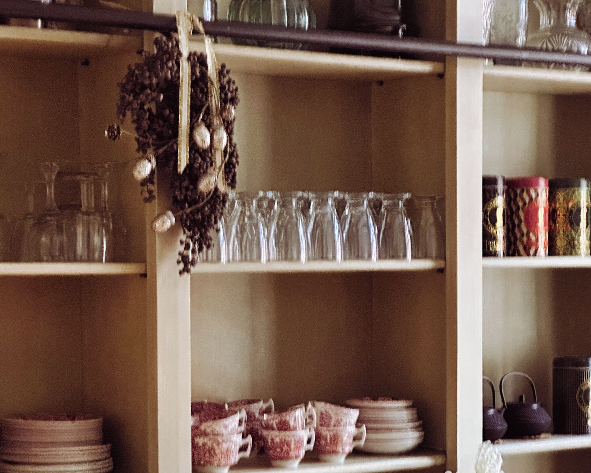 Shelves with glassware, plates, and teapots.