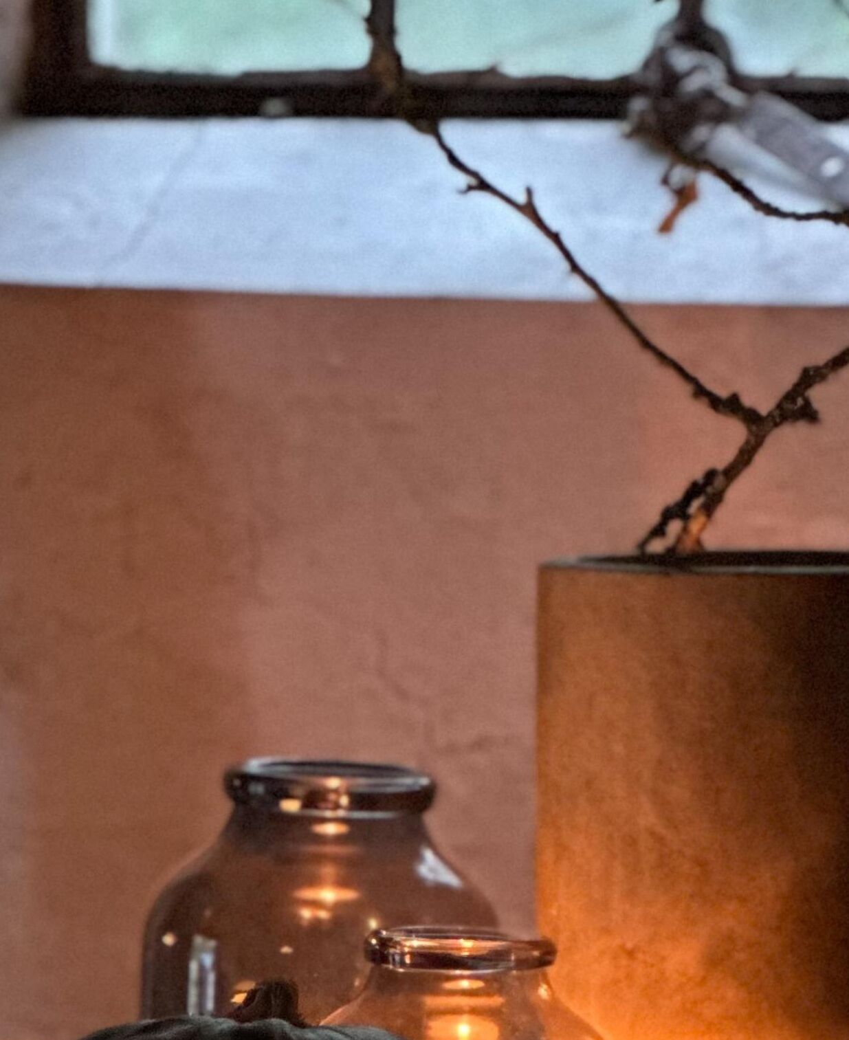 En närbild på två glasburkar med metallock, placerade på en yta med en brun, strukturerad bakgrund.