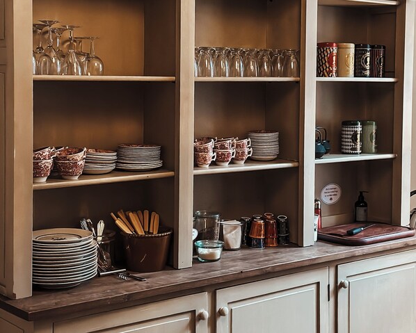 A kitchen with open shelves displaying various dishes, glasses, and utensils. - The Woodland Lodge Gisselfeld (Haslev)