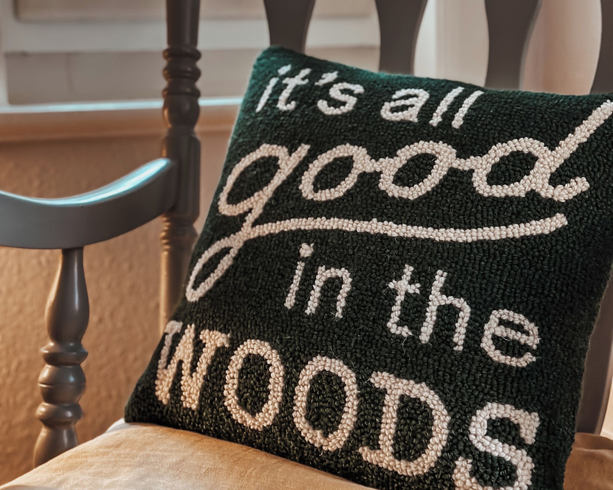 Ein Kissen mit der Aufschrift 'it's all good in the WOODS'.