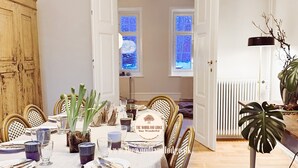 A dining area with a table set for four, surrounded by wicker chairs, and a view of a snowy landscape through the windows. - The Woodland Lodge Gisselfeld (Haslev)