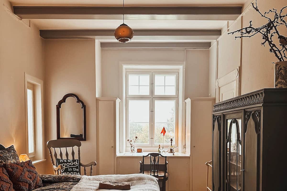 Un dormitorio con cama, cómoda, silla, escritorio y ventana.