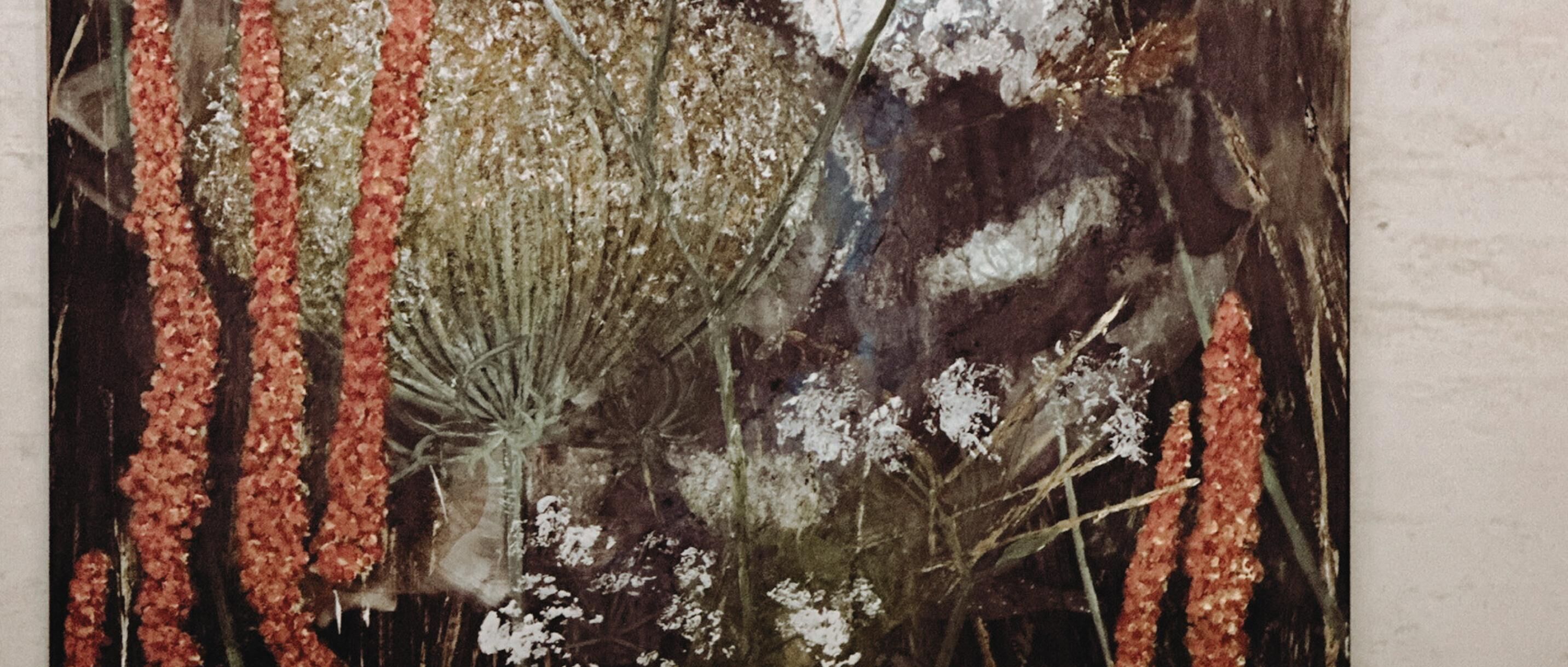 A close-up of a textured wall with vertical patterns and clusters of small, white and red elements.