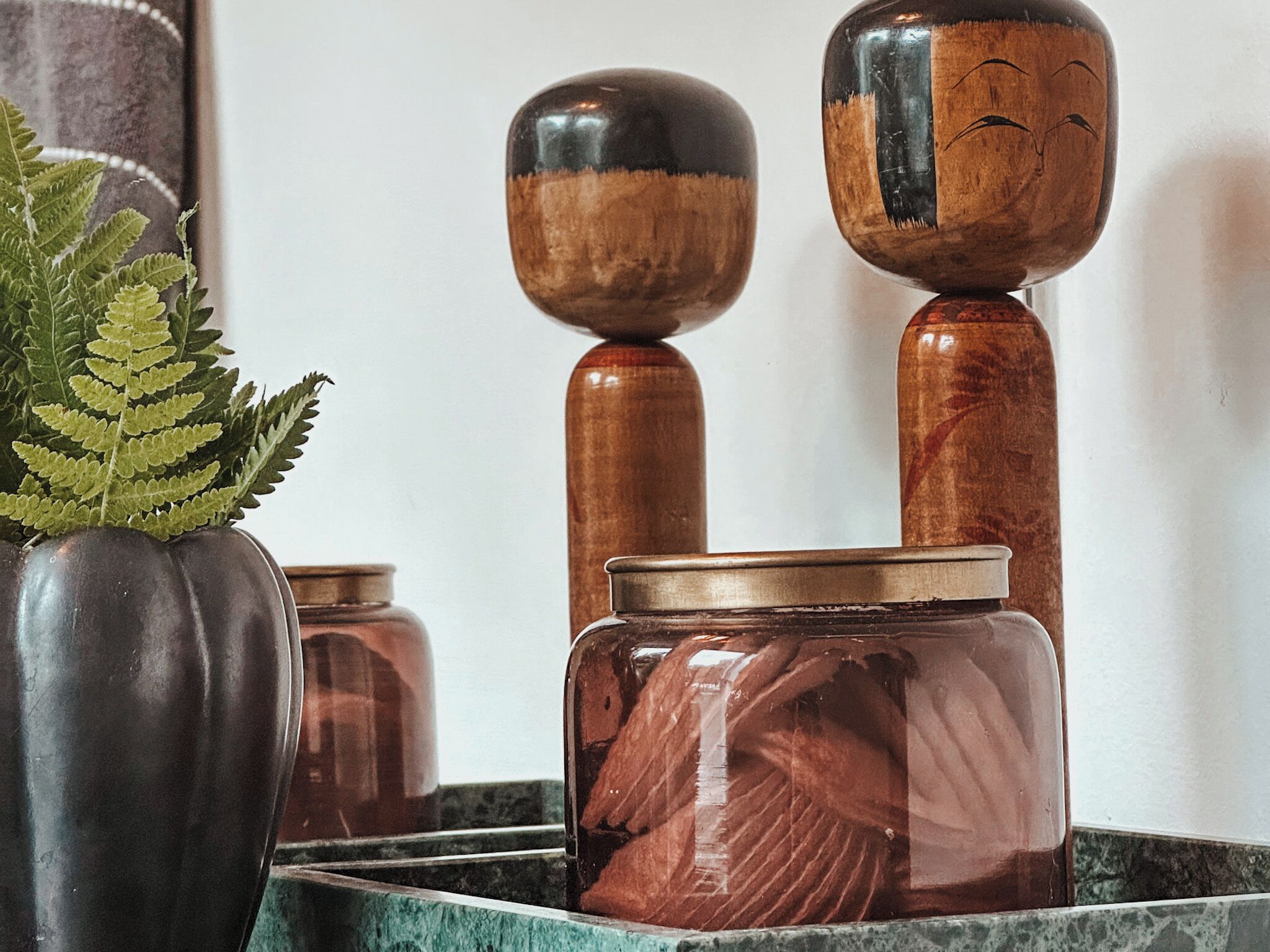 A set of wooden containers with lids, some with reflective surfaces, placed on a tiled surface.