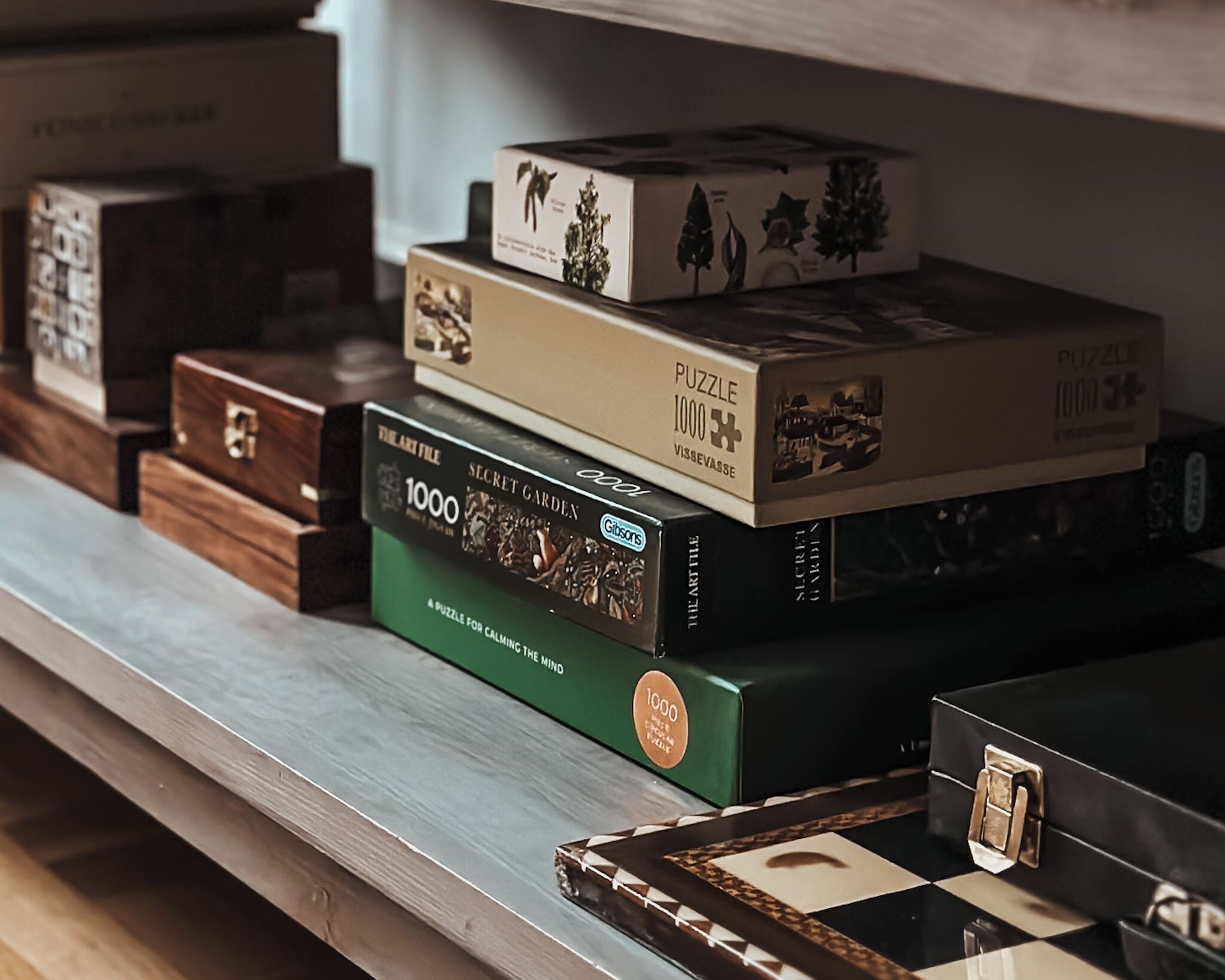 A wooden shelf with various puzzle boxes stacked on it.