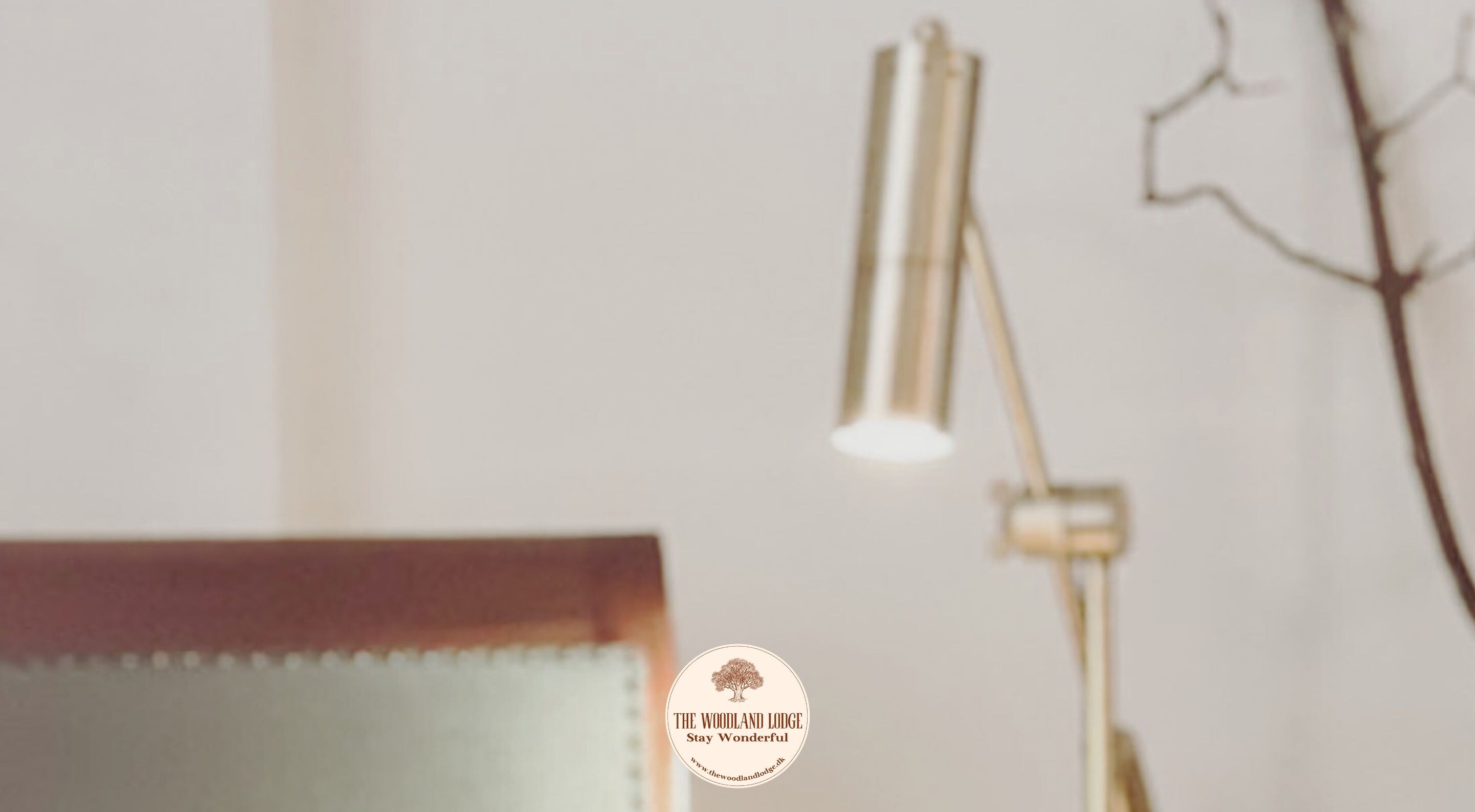 A bedroom with a bed, a bedside lamp, and a wall-mounted light fixture.
