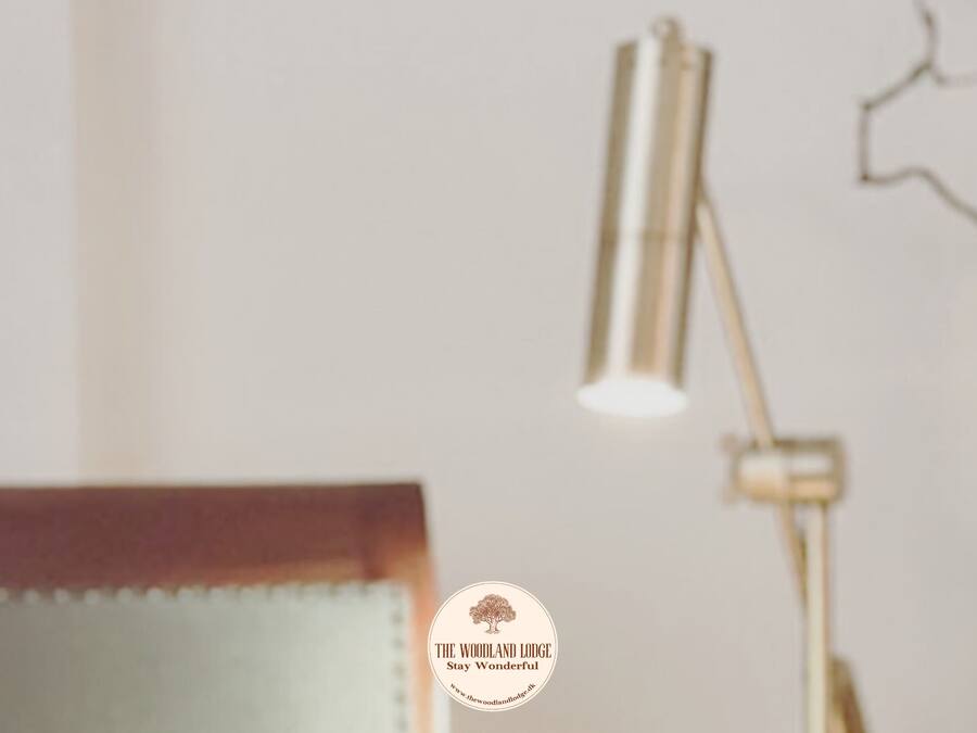 A bedroom with a bed, a bedside lamp, and a wall-mounted light fixture.