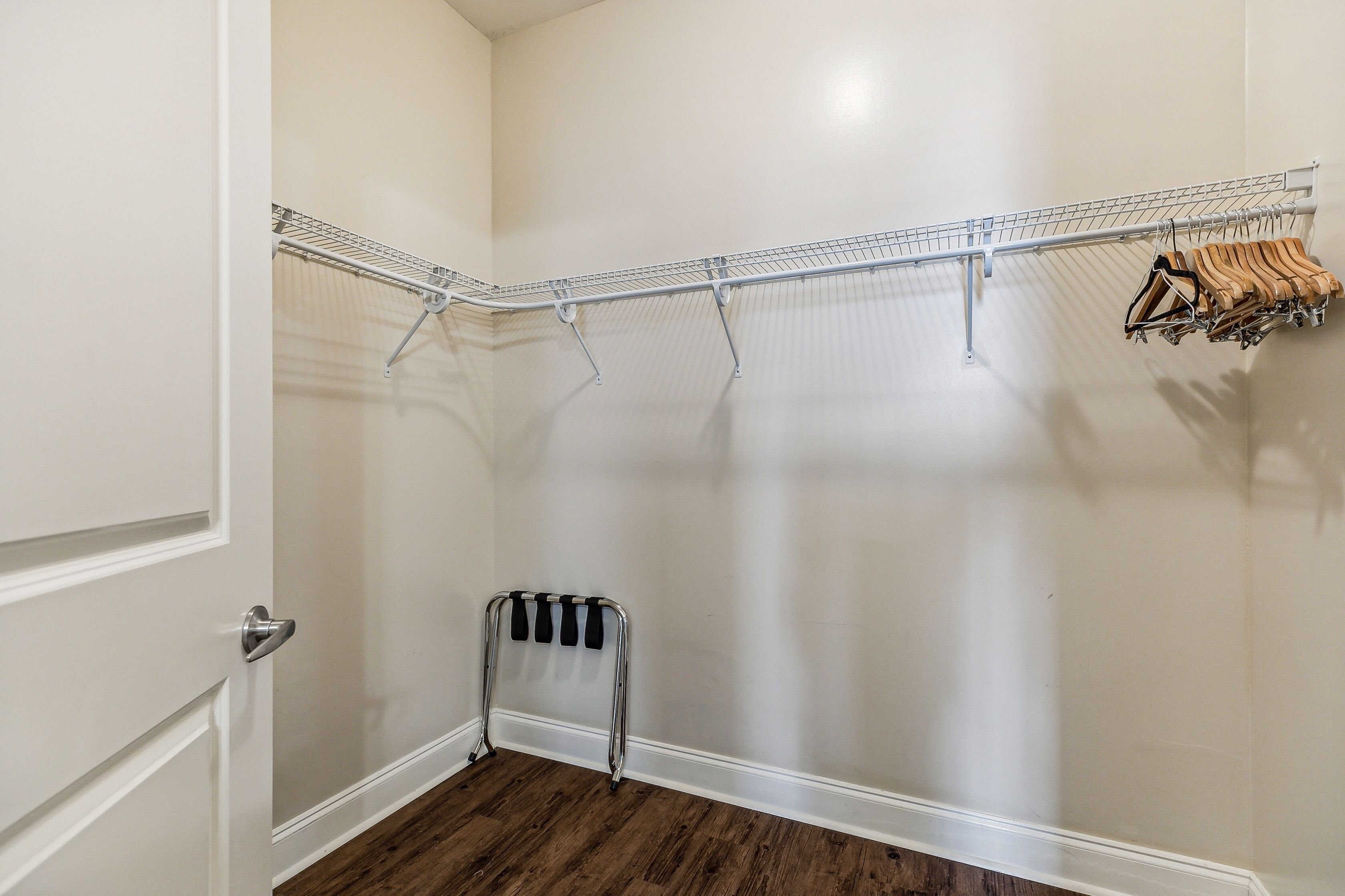 A corner closet with a metal drying rack and a radiator.