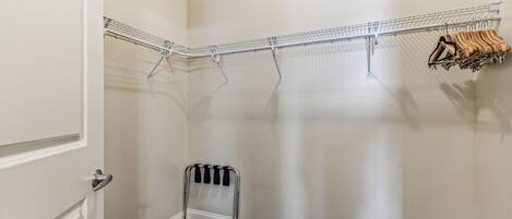 A corner closet with a metal drying rack and a radiator.
