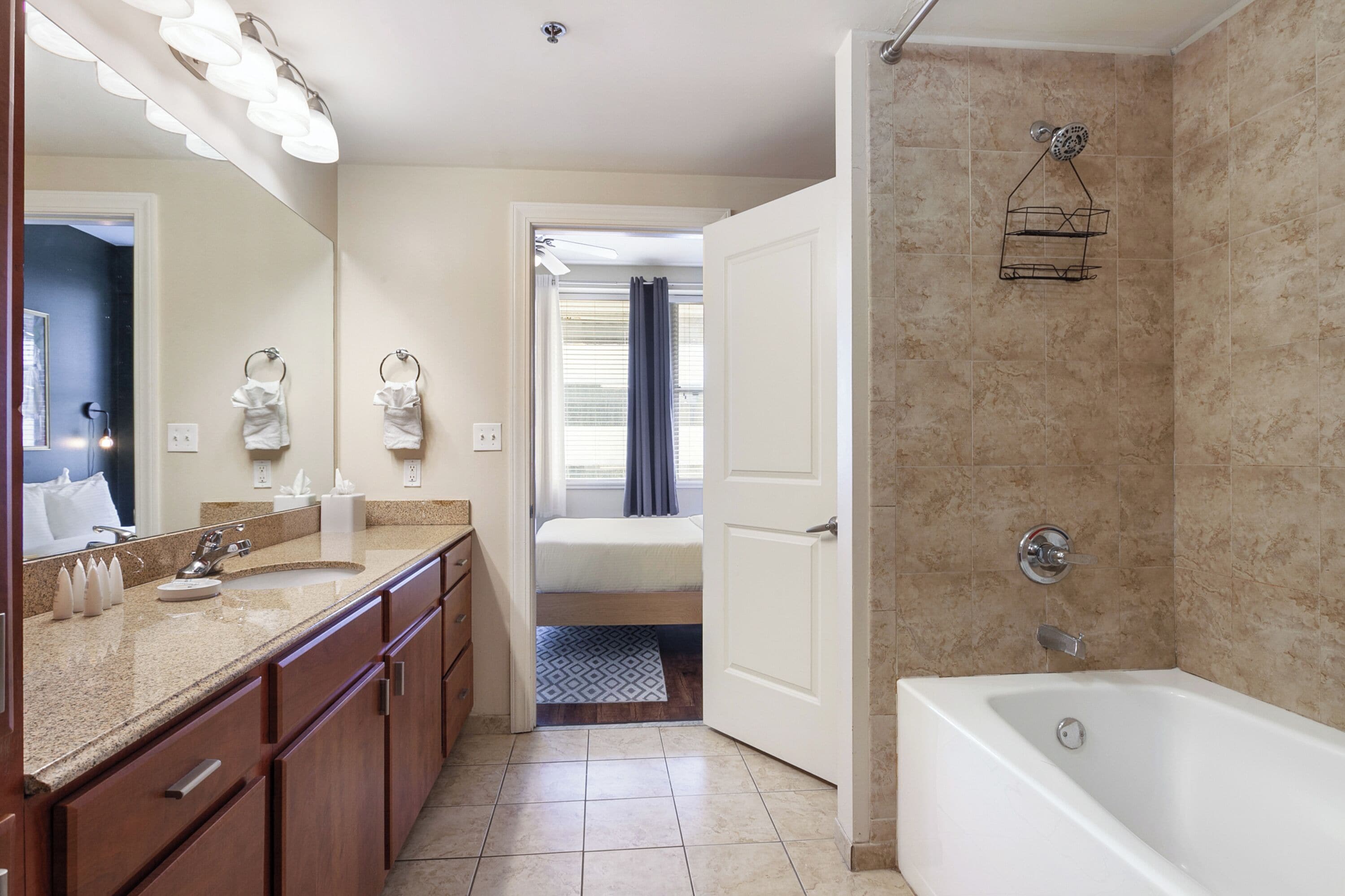 A modern bathroom with a large mirror, a bathtub, and a shower area.