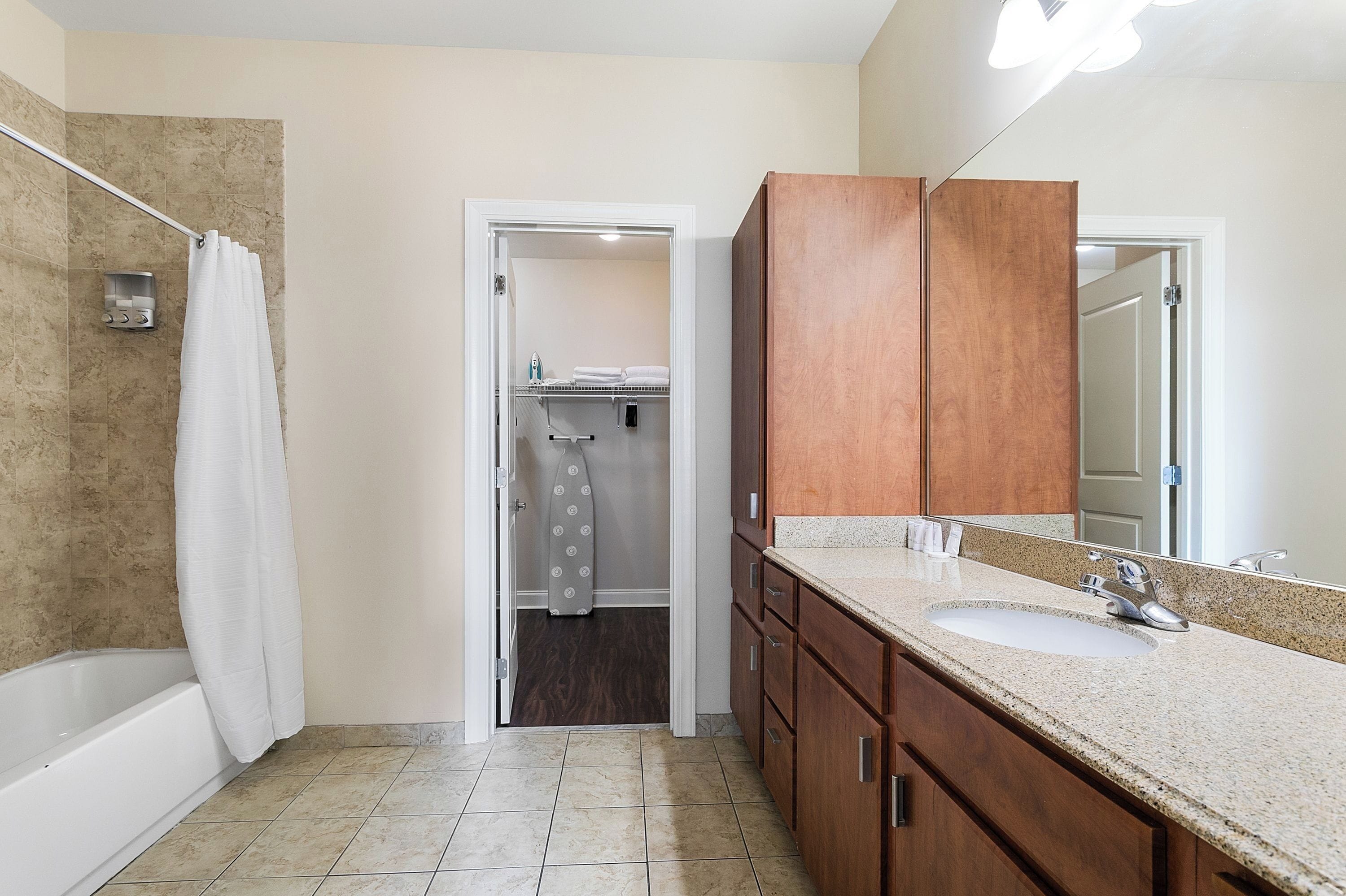 Un baño con bañera, lavamanos y espejo.