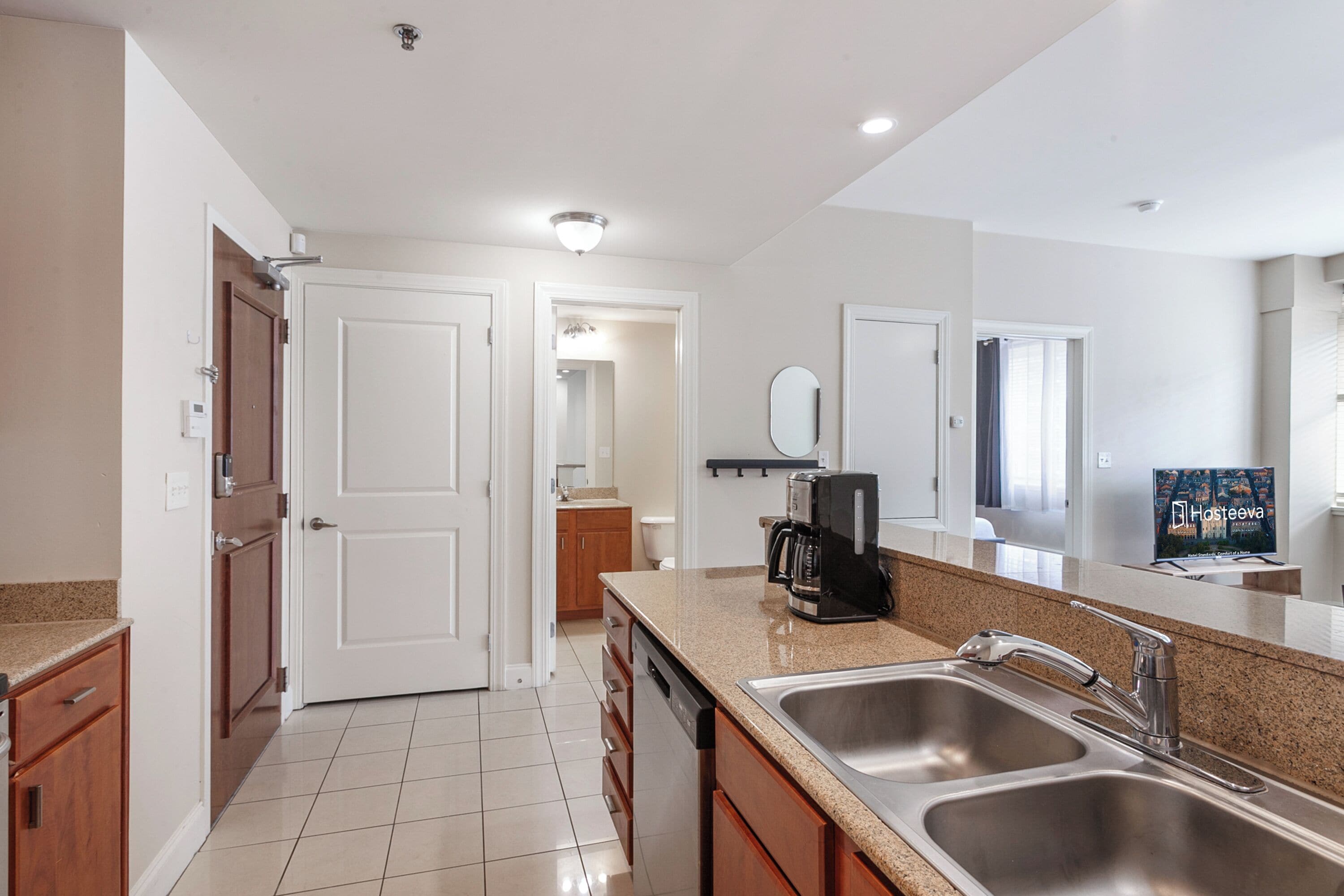 A modern kitchen with stainless steel appliances, a double sink, and a countertop with a coffee maker.