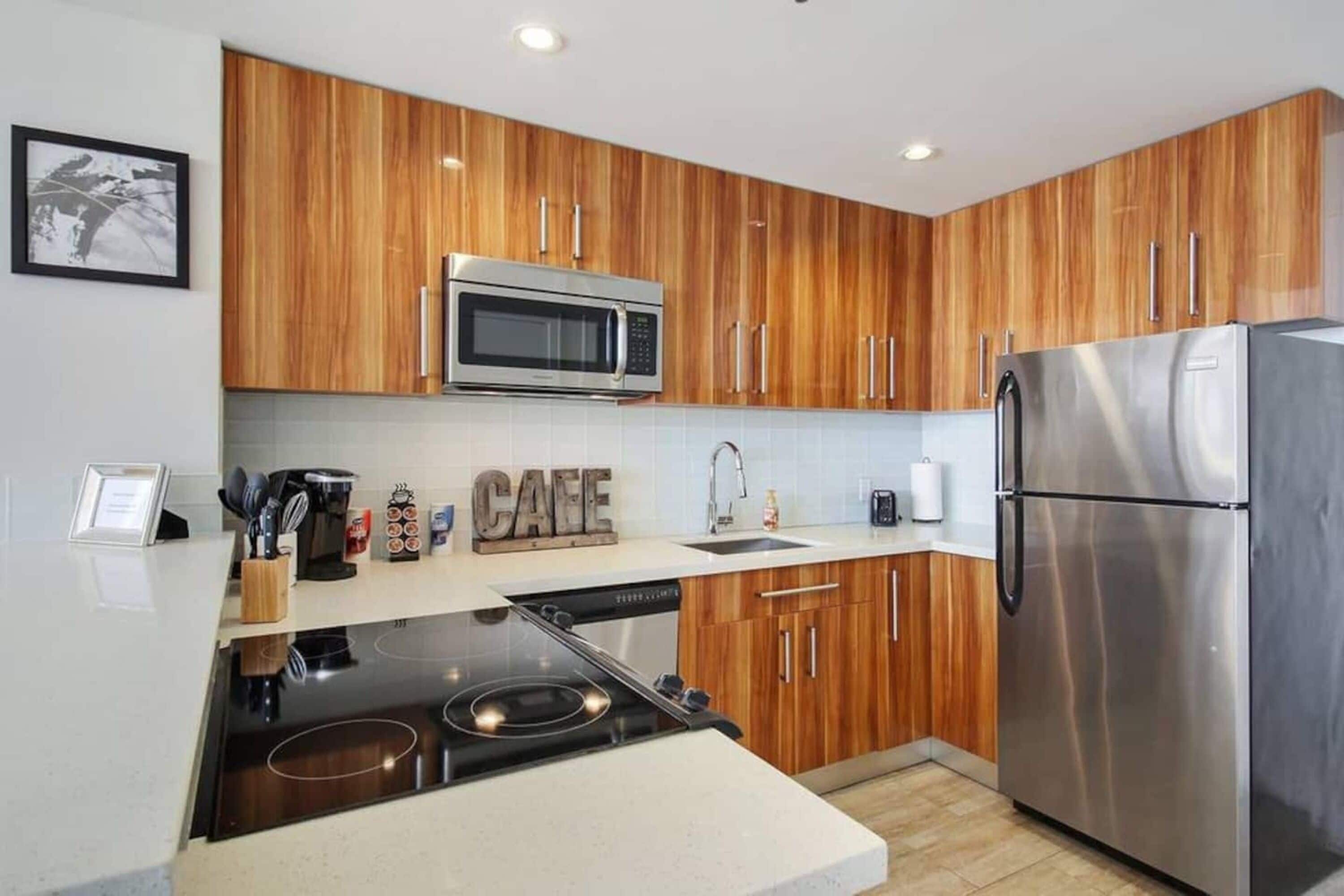 Una cocina moderna con gabinetes de madera, electrodomésticos de acero inoxidable y una estufa integrada.