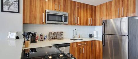 Una cocina moderna con gabinetes de madera, electrodomésticos de acero inoxidable y una estufa integrada.