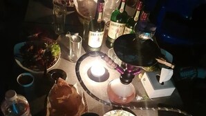 A table set for a meal with various dishes, drinks, and a lit candle. - Club Jawai (Butwal)