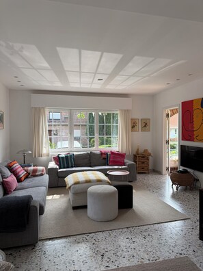 A modern living room with a sofa set, a coffee table, and a television.