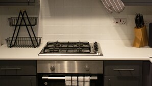 A kitchen with a gas stove, oven, and stainless steel cabinets.