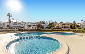 A swimming pool with a clear blue water feature, surrounded by a paved area. - Cozy apartment in Orihuela with WiFi (Orihuela)