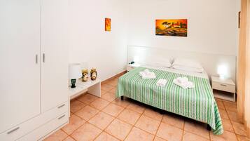 Un dormitorio ordenado con cama, mesitas de noche y armario.